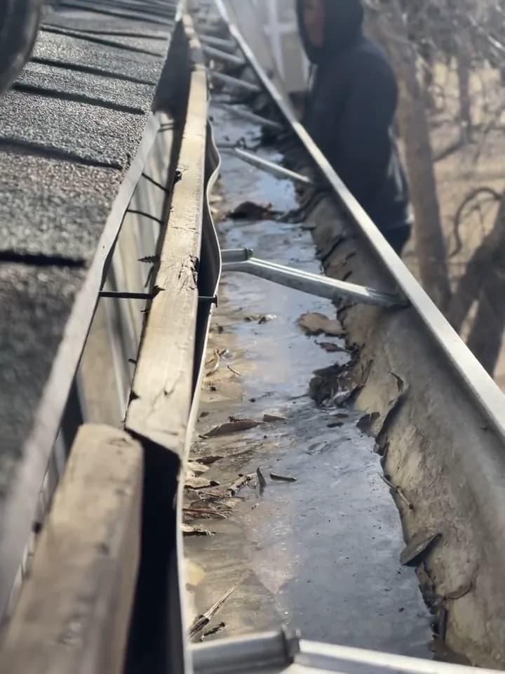 A close view along a gutter beneath existing shingles