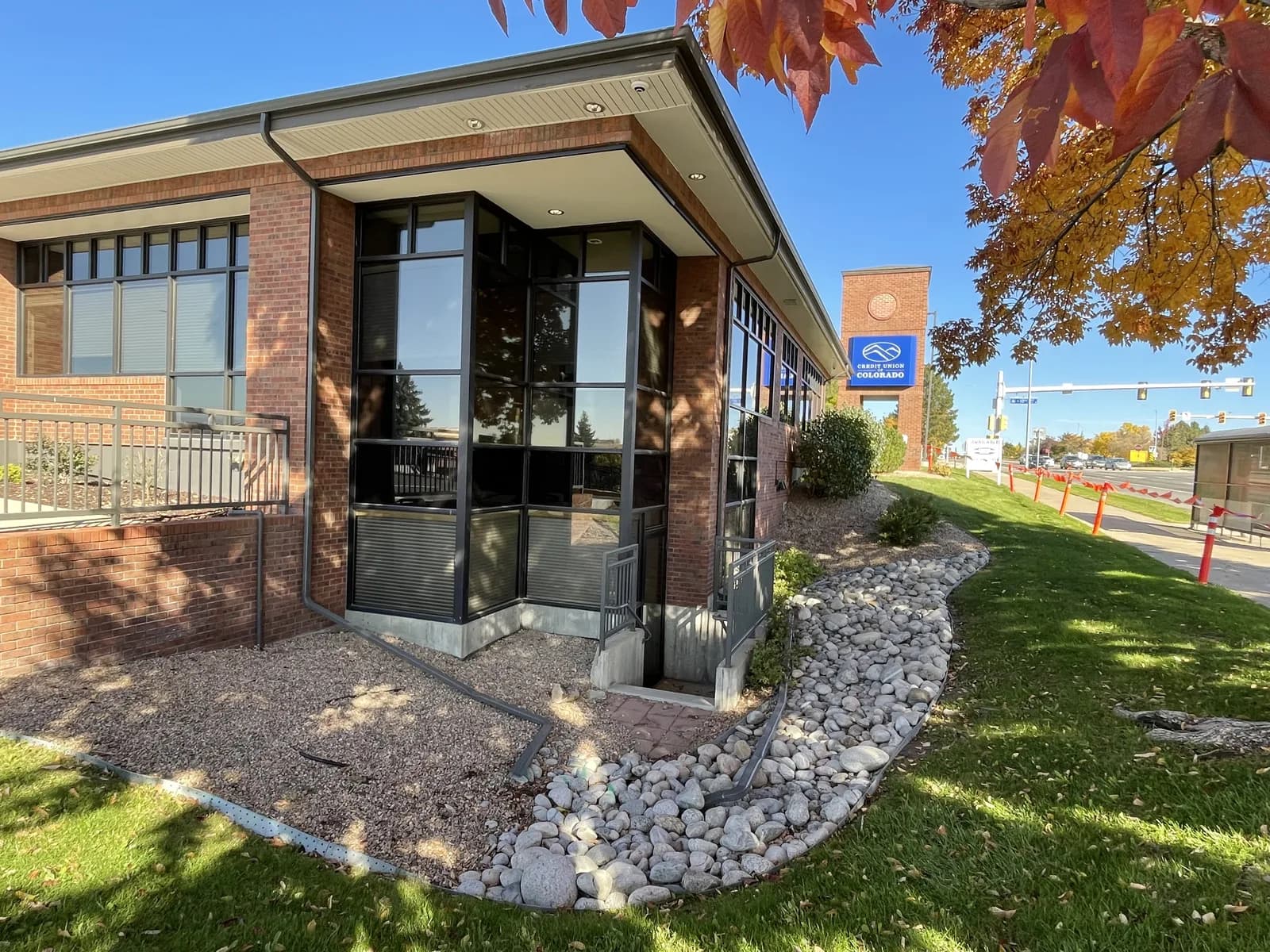 Dark gutters and downspouts around a brick commercial building with tall windows